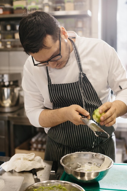 La sezione centrale è un ritratto di uno chef che grattugia la scorza di lime Il concetto di cucina in un ristorante