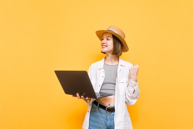 La signora con il cappello tiene in mano un laptop ed è felice di vincere lo spazio di copia