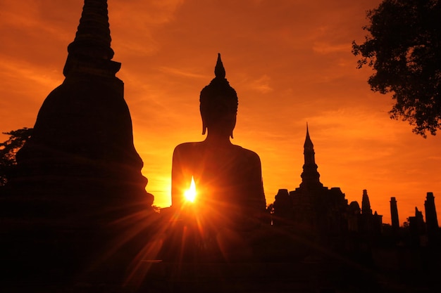 La silhouette della statua del tempio durante il tramonto