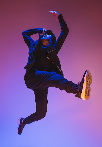 La silhouette di un giovane ballerino di break dance hip hop che balla su colorato