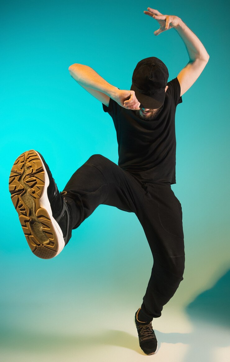La silhouette di un giovane break dancer hip hop che danza su uno sfondo colorato