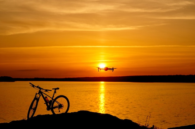 La silhouette di una bicicletta in acqua al tramonto in una calda giornata estiva Concetto all'aperto