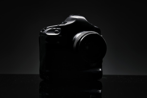 La silhouette di una fotocamera reflex professionale su sfondo nero Presentazione di un nuovo prodotto