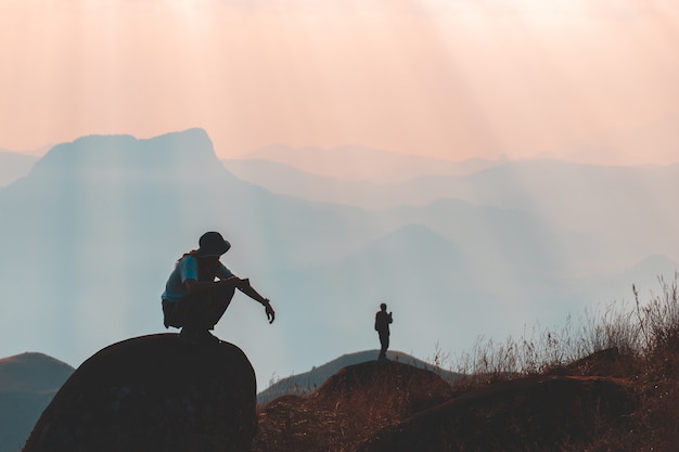 La siluetta dell'uomo ostacola la mano sul picco della montagna