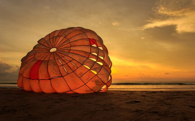 La siluetta dell&#39;uomo sta preparando la navigazione di para alla spiaggia del tramonto in Tailandia