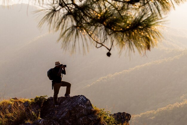 La siluetta dell'uomo tiene le mani sulla vetta della montagna,concetto di successo