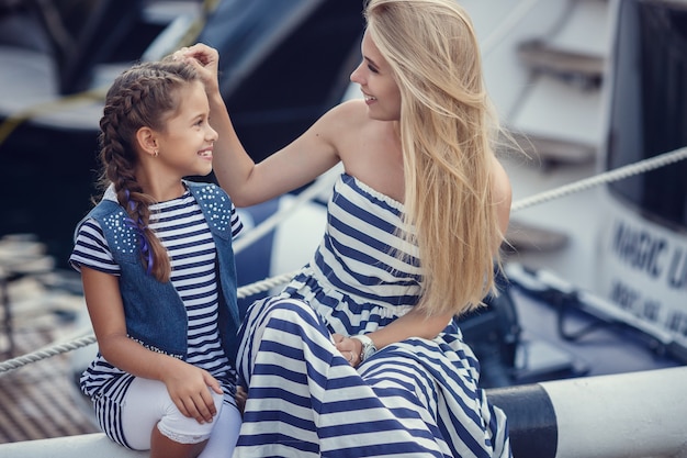 La sorella maggiore e le sorelle minori e un fratello in stile marinaro sullo sfondo di barche e yacht