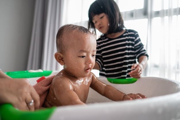 La sorella utile lava il suo fratellino durante l'ora del bagno