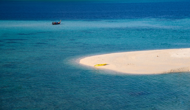 La spiaggia bianca con canoa gialla nel mare tropicale