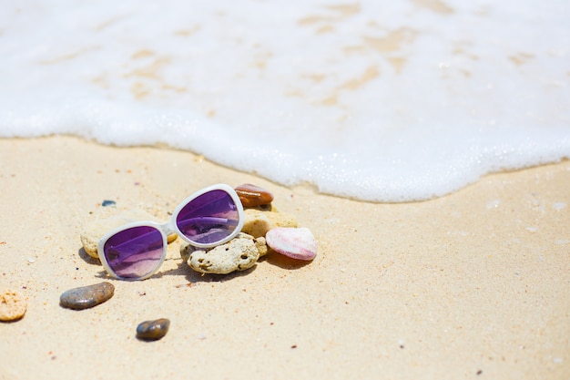 La spiaggia con gli occhiali da sole sulla roccia