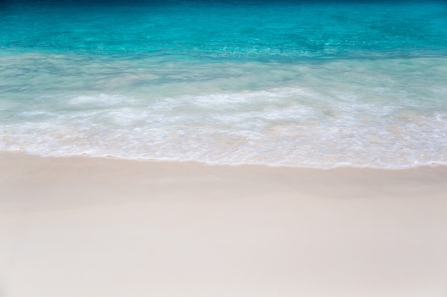 La spiaggia con sabbia bianca e acqua turchese con onde