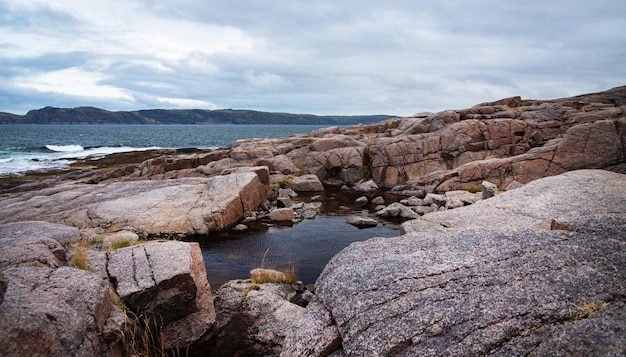 La spiaggia sull'oceano settentrionale è fatta di pietre ricoperte di muschio colorato. Teriberka, Mare di Barents, regione di Murmansk, penisola di Kola
