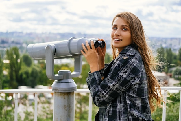 La splendida donna tiene il binocolo turistico per guardarli attraverso