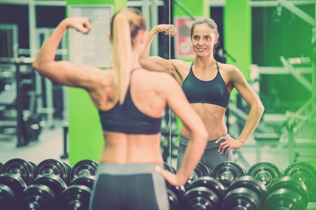 La sportiva posa davanti allo specchio in palestra