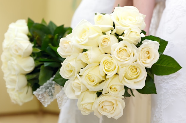 La sposa a un matrimonio con in mano un mazzo di fiori. La sposa in abito bianco a una cerimonia di matrimonio con un mazzo di rose.