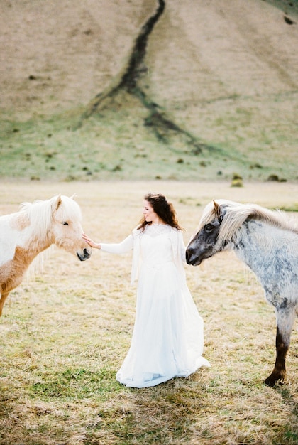 La sposa accarezza un cavallo rosso nel pascolo L'Islanda