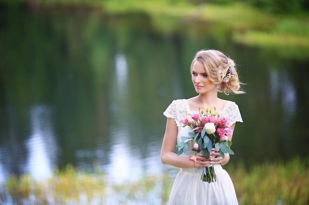 La sposa ammirando il tramonto sulla riva del fiume.