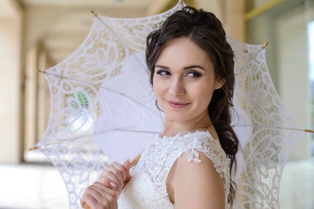 La sposa con ombrello bianco