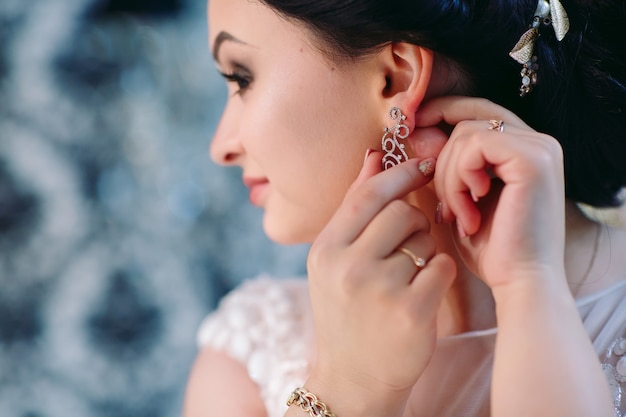 La sposa corregge l'orecchino, Bellissimi orecchini e le mani della sposa