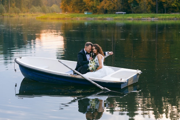 La sposa e lo sposo in una barca a remi sul lago