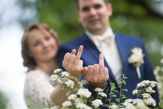 La sposa e lo sposo mostrano gli anelli nuziali con i fiori
