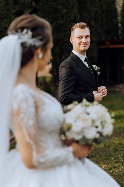 La sposa e lo sposo si guardano il giorno del loro matrimonio sulla spalla di una coppia di sposi tenerezza e amore negli occhi