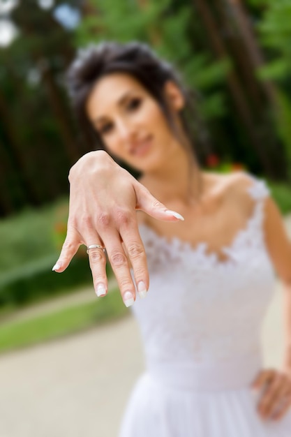 La sposa felice mostra l'anello al dito. Profondità di campo.