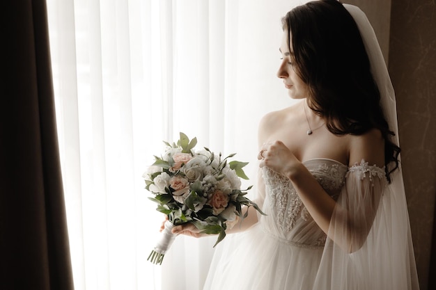 la sposa in abito bianco con un mazzo di fiori