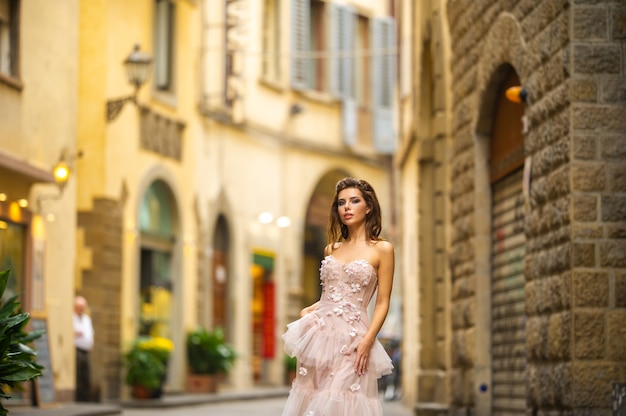 La sposa in un abito da sposa rosa cammina a Firenze, Italia.