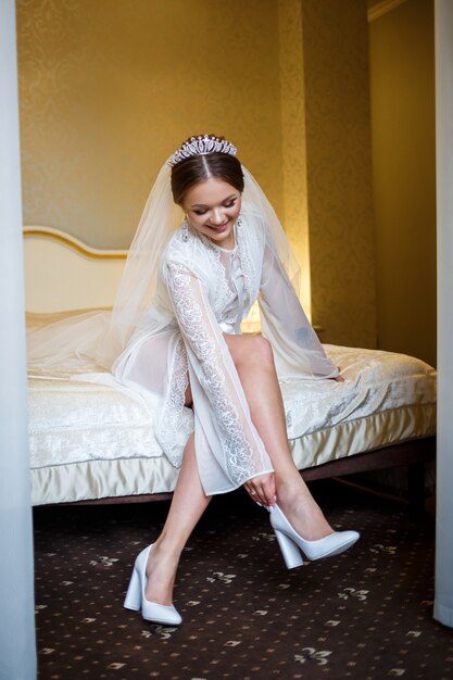 La sposa indossa scarpe bianche il giorno del matrimonio