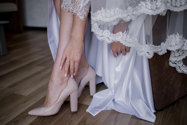 La sposa si mette le scarpe da sposa al mattino