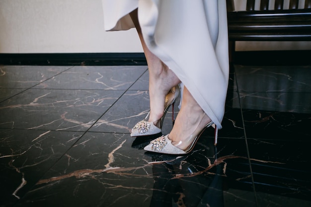 la sposa si mette le scarpe da sposa la mattina prima della cerimonia nuziale, le gambe della sposa