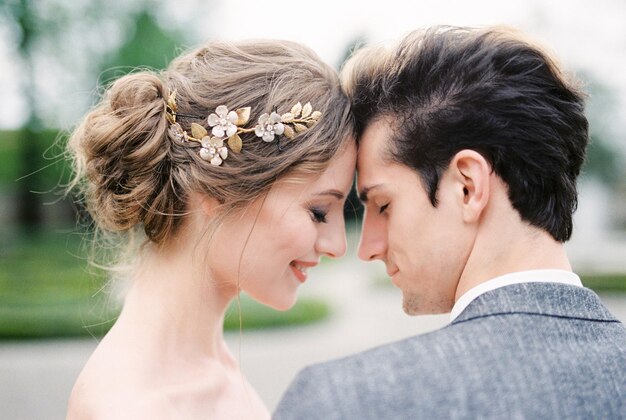 La sposa sorridente tocca la fronte dello sposo con la fronte Ritratto