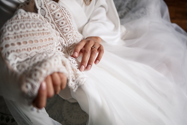 La sposa tiene in mano un abito bianco il giorno del matrimonio.