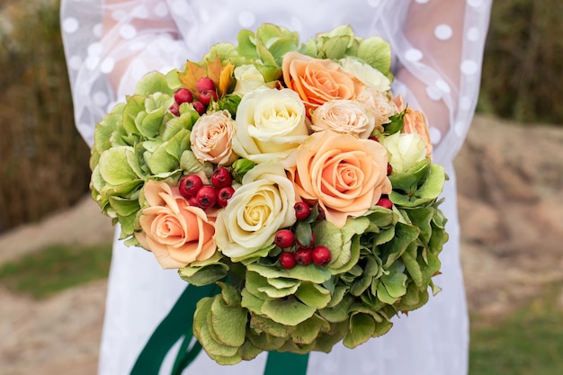 La sposa tiene in mano un bellissimo mazzo di rose il giorno del suo matrimonio