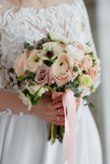 La sposa tiene in mano un bouquet da sposa. Bouquet da sposa nelle mani della sposa.