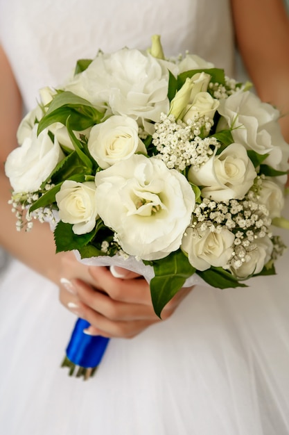 La sposa tiene in mano un bouquet da sposa