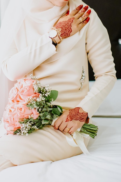 La sposa tiene in mano un bouquet da sposa.