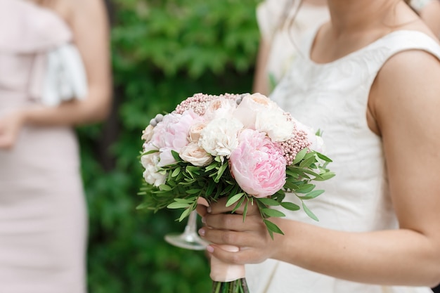 La sposa tiene un bellissimo bouquet da sposa di peonie
