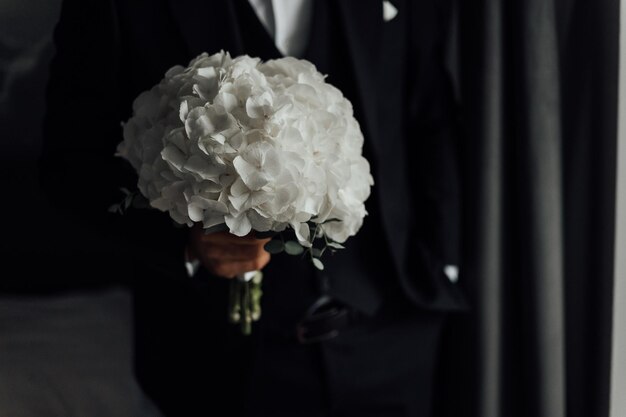 La sposa tiene un bouquet da sposa dettagli di nozze dell'abito da sposa