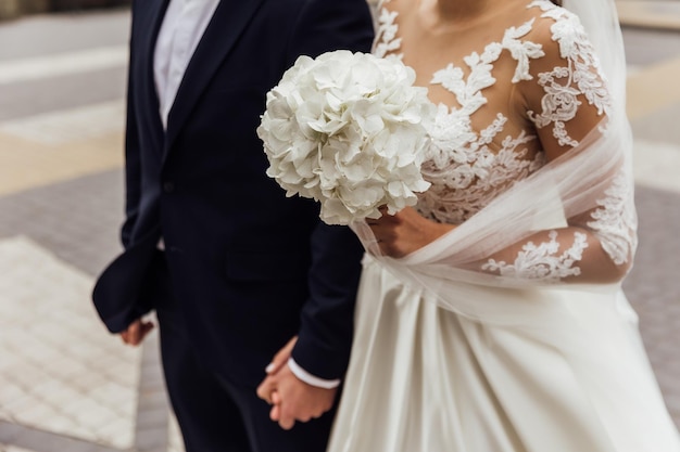 La sposa tiene un bouquet da sposa dettagli di nozze dell'abito da sposa