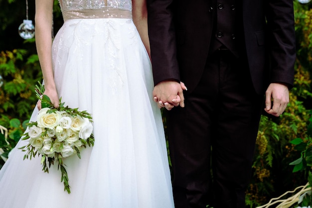 La sposa tiene un bouquet da sposa nelle sue mani fiori il giorno delle nozze