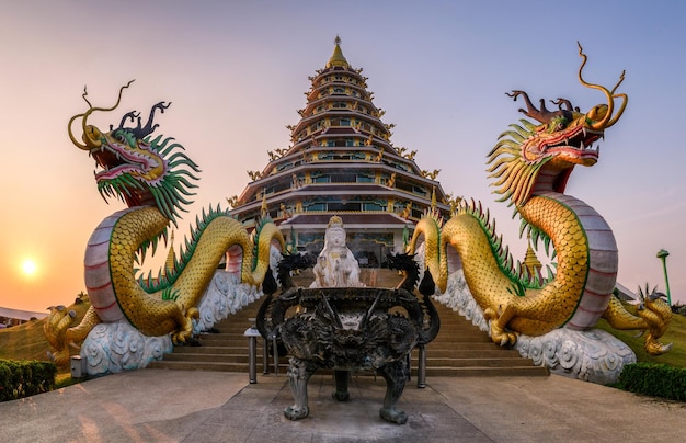 La statua dei draghi è tra la pagoda al tramonto