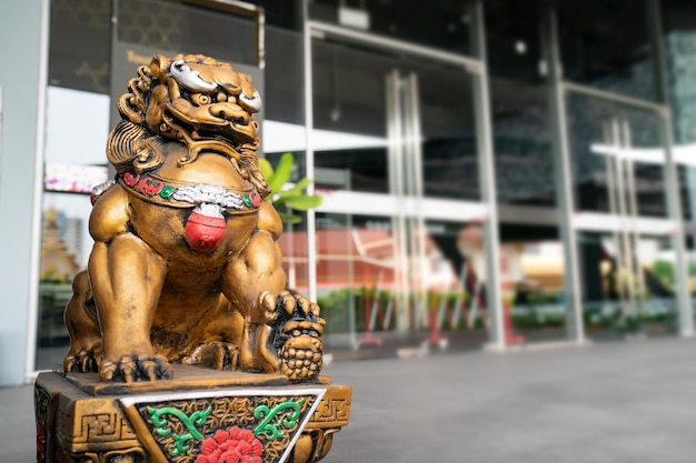 La statua del leone del dio dorato cinese è l'imperatore dell'ornamento della struttura zen dell'Asia davanti alla porta per proteggere la cosa cattiva che entra