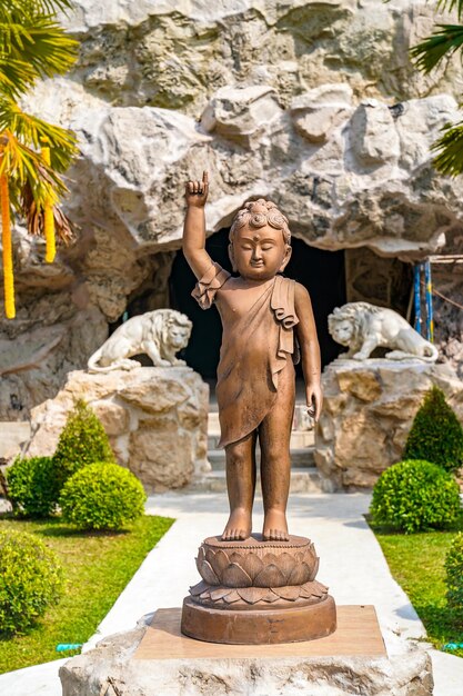 La statua del piccolo Buddha in bronzo di rame punta il dito verso il cielo