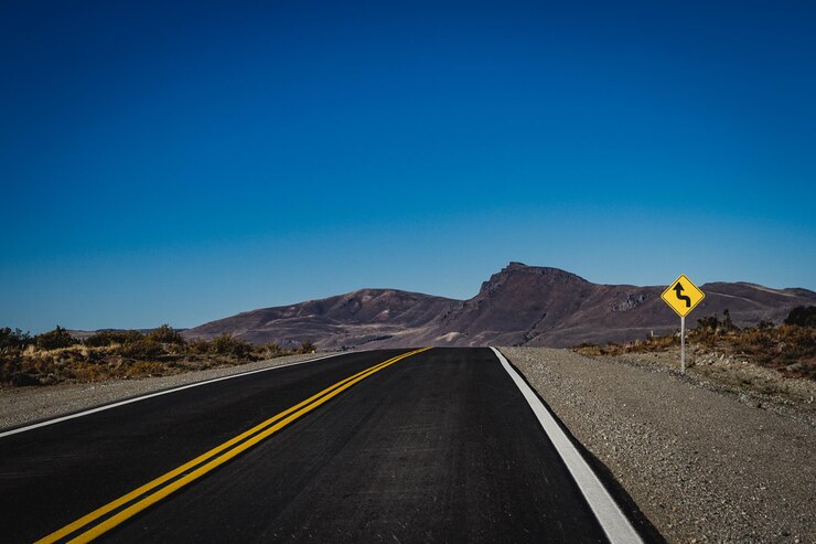 Foto la strada che porta verso la montagna contro un cielo blu limpido