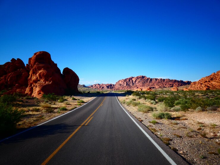 Foto la strada che porta verso le montagne contro un cielo limpido