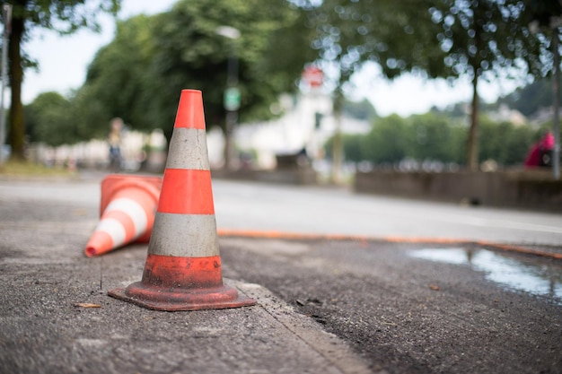 La strada del cono stradale funziona in città sfocata