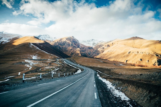 La strada in mezzo alle montagne contro il cielo
