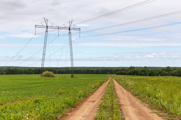 La strada nel campo vicino alla linea elettrica. Bel paesaggio